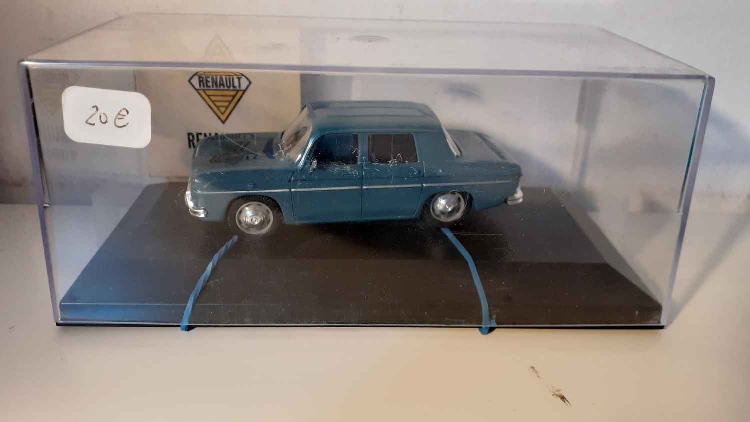 Renault 8 bleue foncée de 1968 (voiture tenue avec élastiques)